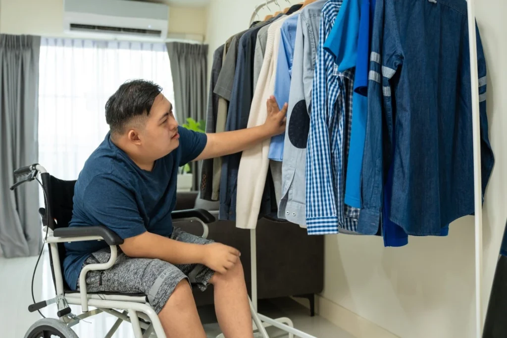 Disabled boy in wheelchair picking out clothes
