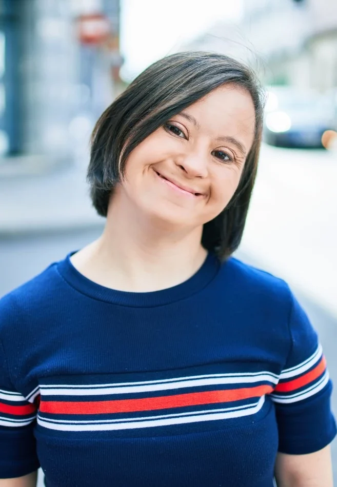 Girl with down syndrome smiling at camera